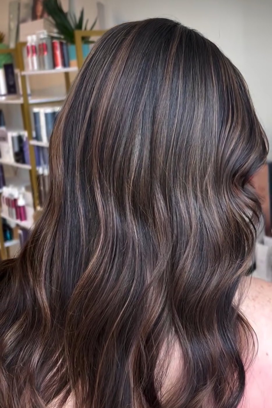 Dimensional brunette balayage with soft face-framing color, shown from the side in natural light