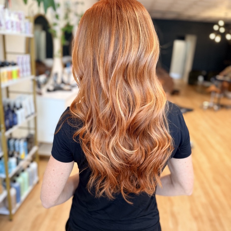 Vivid copper-red hair with hand-painted balayage and dimensional waves, seen from behind