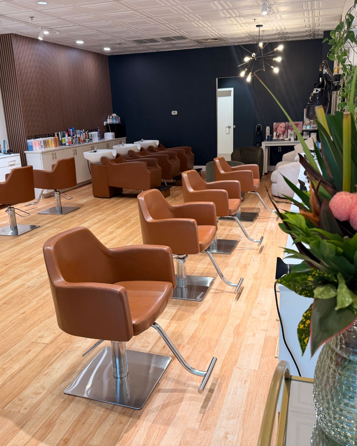 Fresh flowers beside the cognac styling chairs on the salon floor